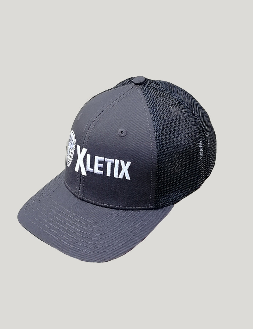 Dunkelgraue Trucker-Cap mit schwarzem Netzrücken und weiß gesticktem XLETIX-Logo vorn.
